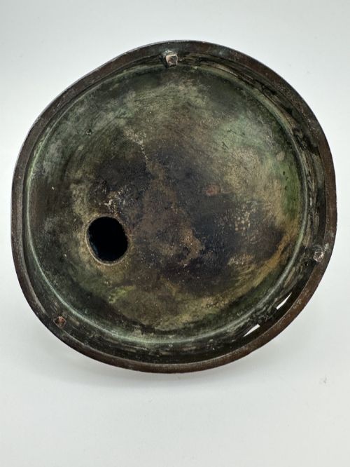 A dark patinated bronze tripod censer with a lid surmounted by a Qilin finial and featuring two tall pierced handles. View X