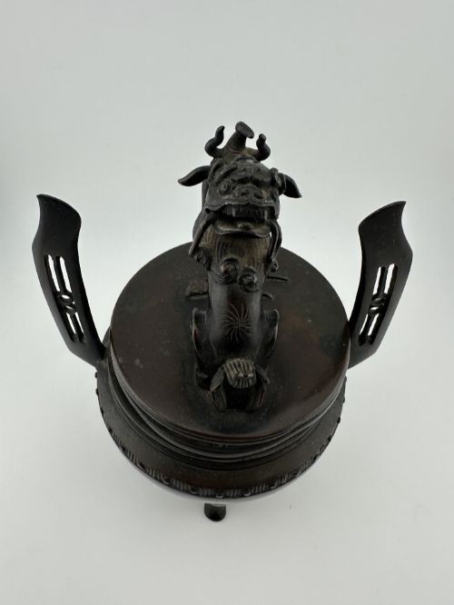 A dark patinated bronze tripod censer with a lid surmounted by a Qilin finial and featuring two tall pierced handles. View XI