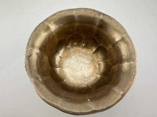 An antique Chinese export white metal footed bowl featuring chased floral patterns and bird motifs within lobed panels. View IV