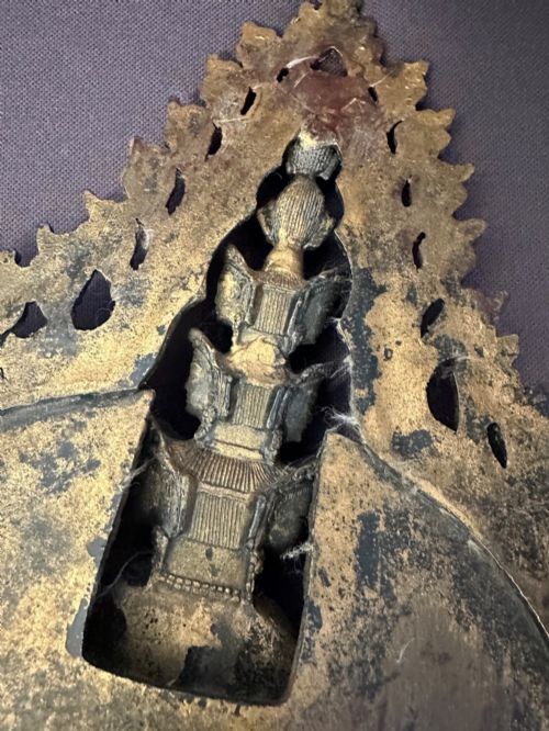 A dark bronze Tibetan sculpture depicting the eleven-headed deity Avalokiteshvara standing on a tiered lotus pedestal against an ornate halo. View XV