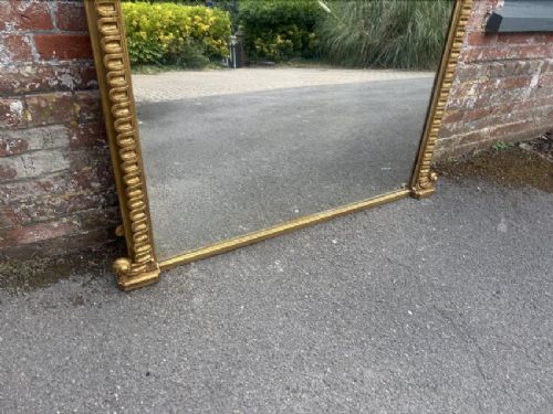 A large 19th-century overmantel mirror featuring an arched gold giltwood frame with fluted moulding detailing and a flat base. View III