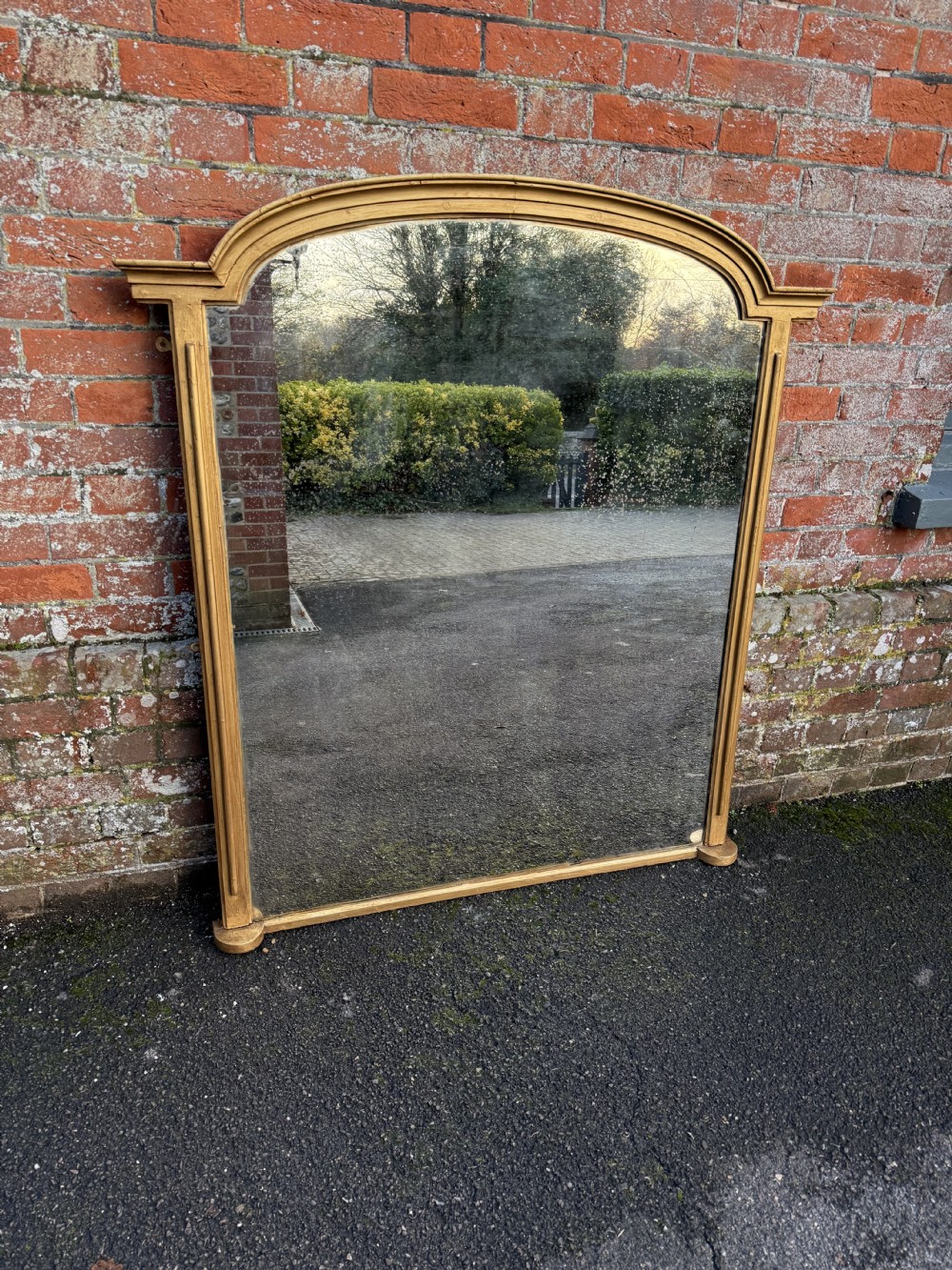 A large 19th-century giltwood overmantel mirror featuring an arched top frame decorated with beaded moulding and pilaster side columns. View VII