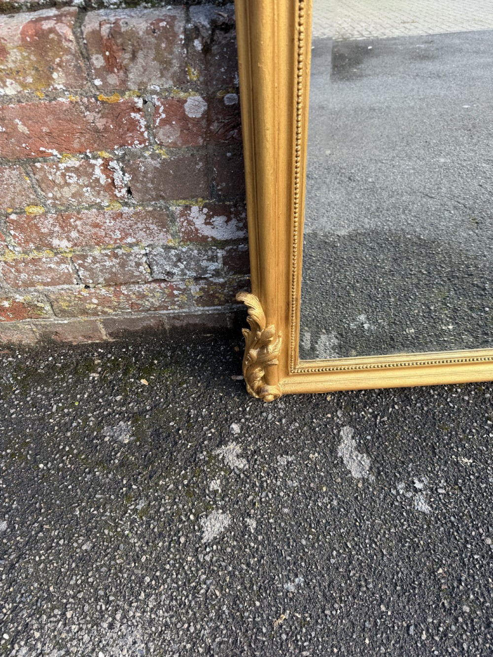 A large 19th-century French gilt wood and gesso mirror featuring a carved cherub frieze panel and an ornate crested top. View V