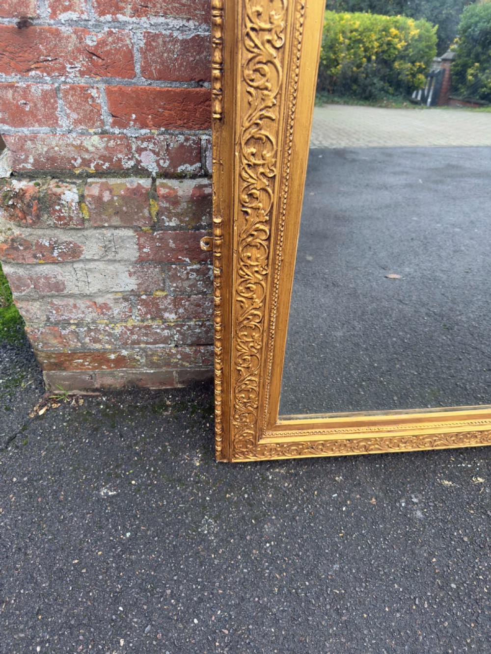 A large rectangular 19th-century English giltwood wall mirror featuring an ornate carved gesso frame with foliate moulding and a gold leaf finish. View III