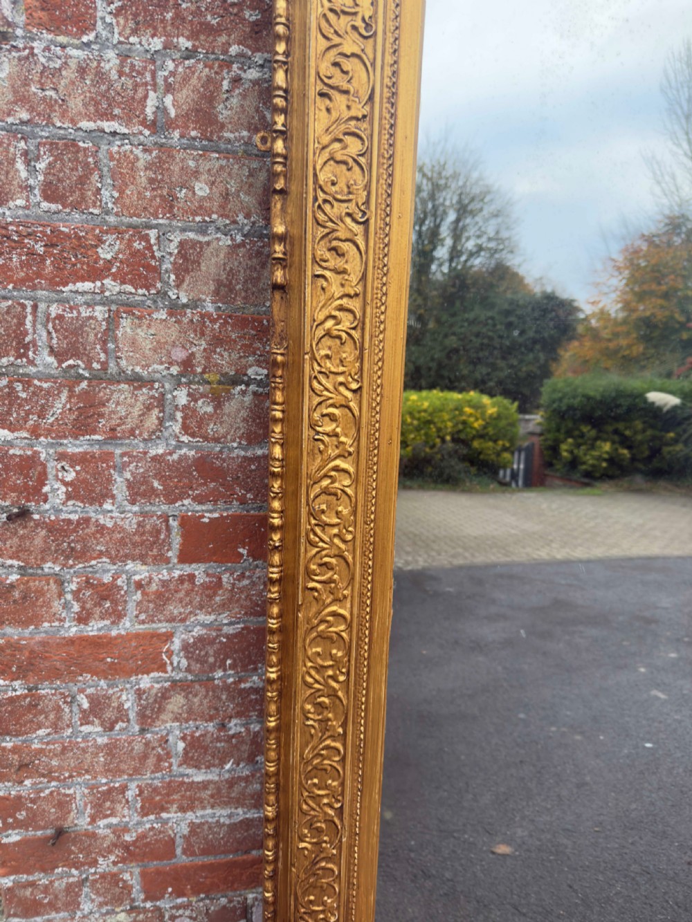A large rectangular 19th-century English giltwood wall mirror featuring an ornate carved gesso frame with foliate moulding and a gold leaf finish. View IV