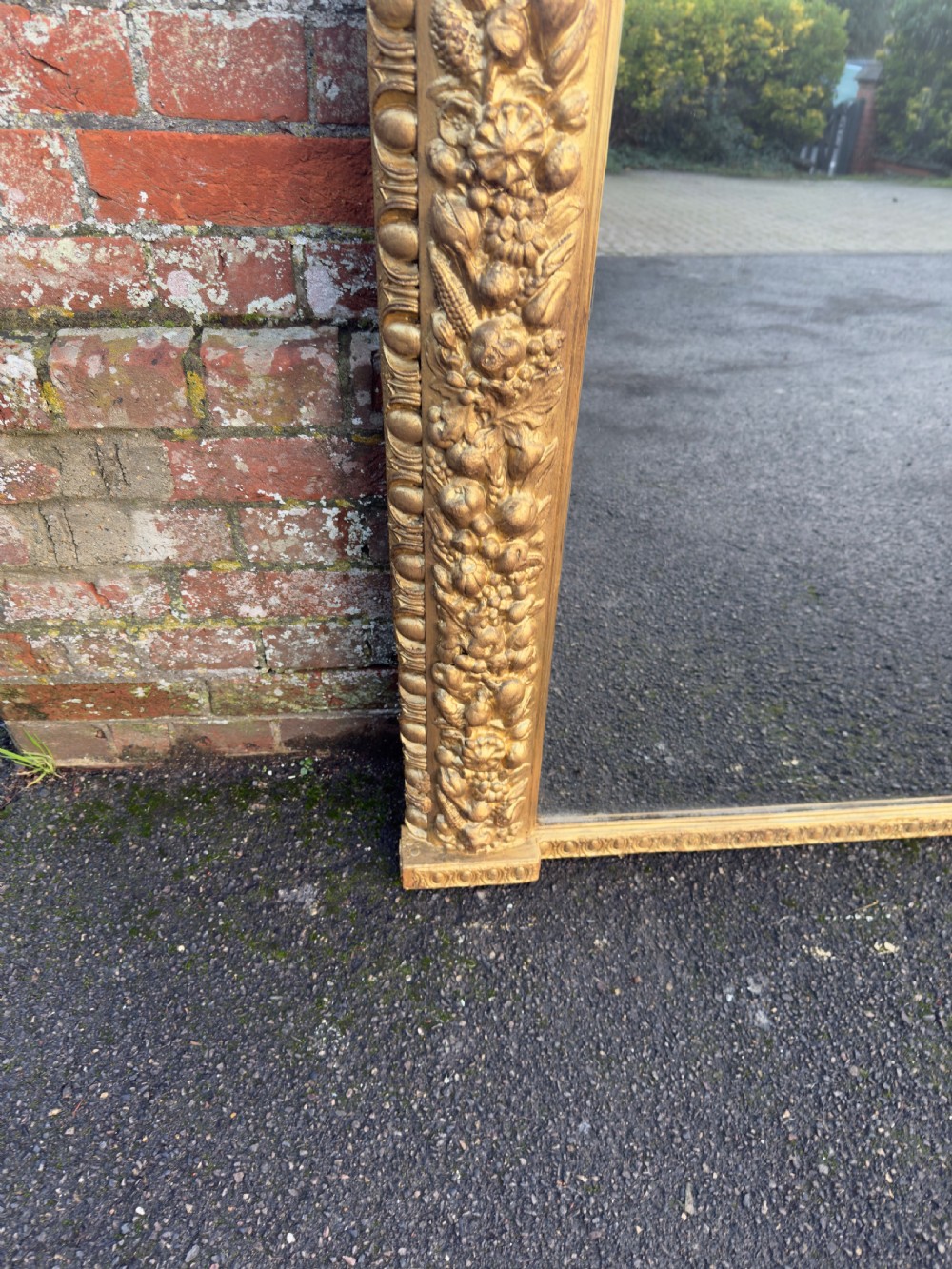 A large nineteenth-century Victorian giltwood and gesso overmantel mirror featuring an arched upper frame embellished with dense floral and fruit relief carvings. View III