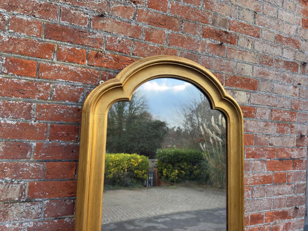 A tall 19th-century giltwood full-length mirror featuring a shaped arched top and continuous moulded frame. View II