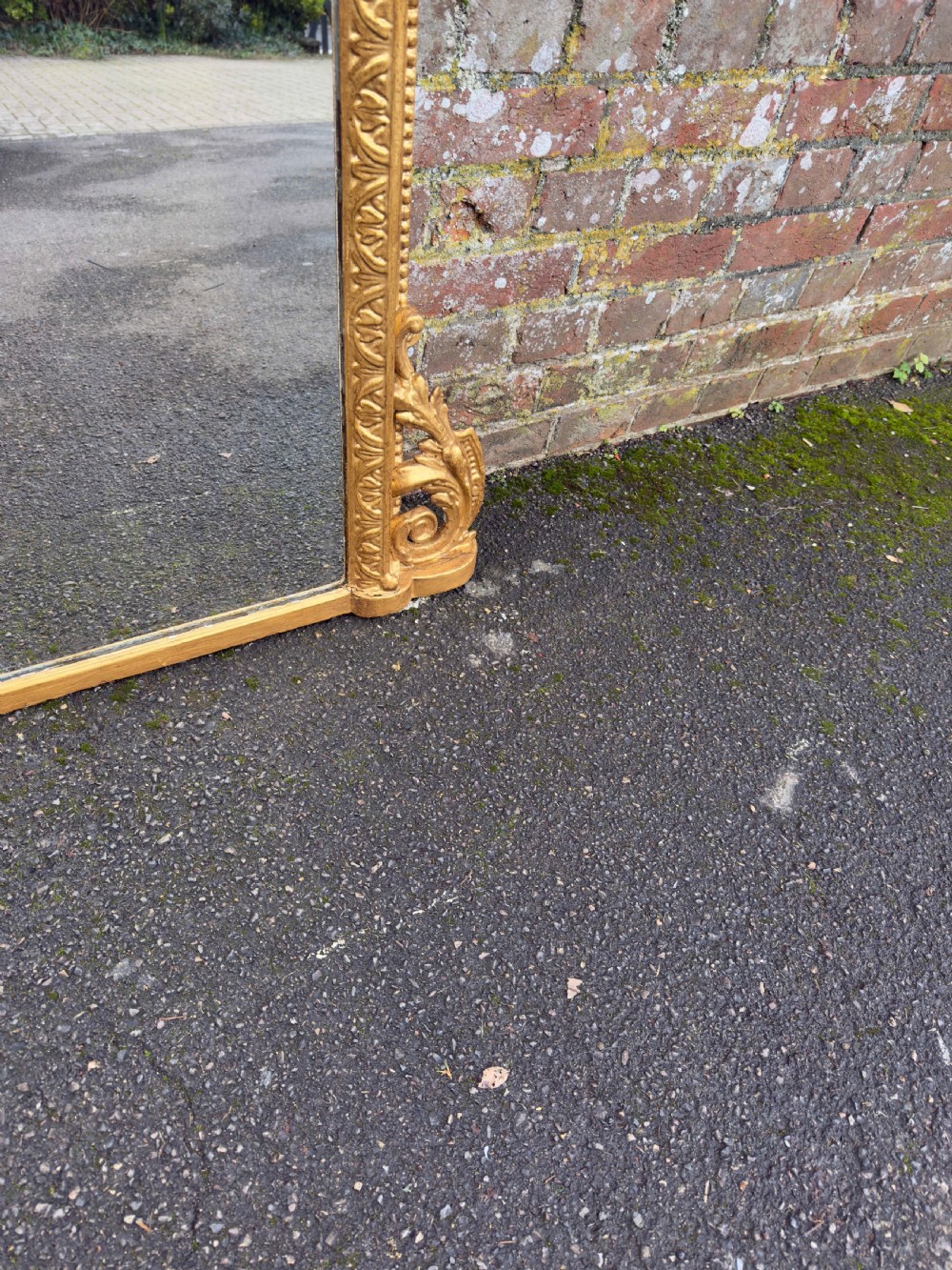 A large 19th-century rectangular overmantel mirror featuring a gilded gesso frame with floral moulding, scrolled side feet, and a stepped top cornice. View V