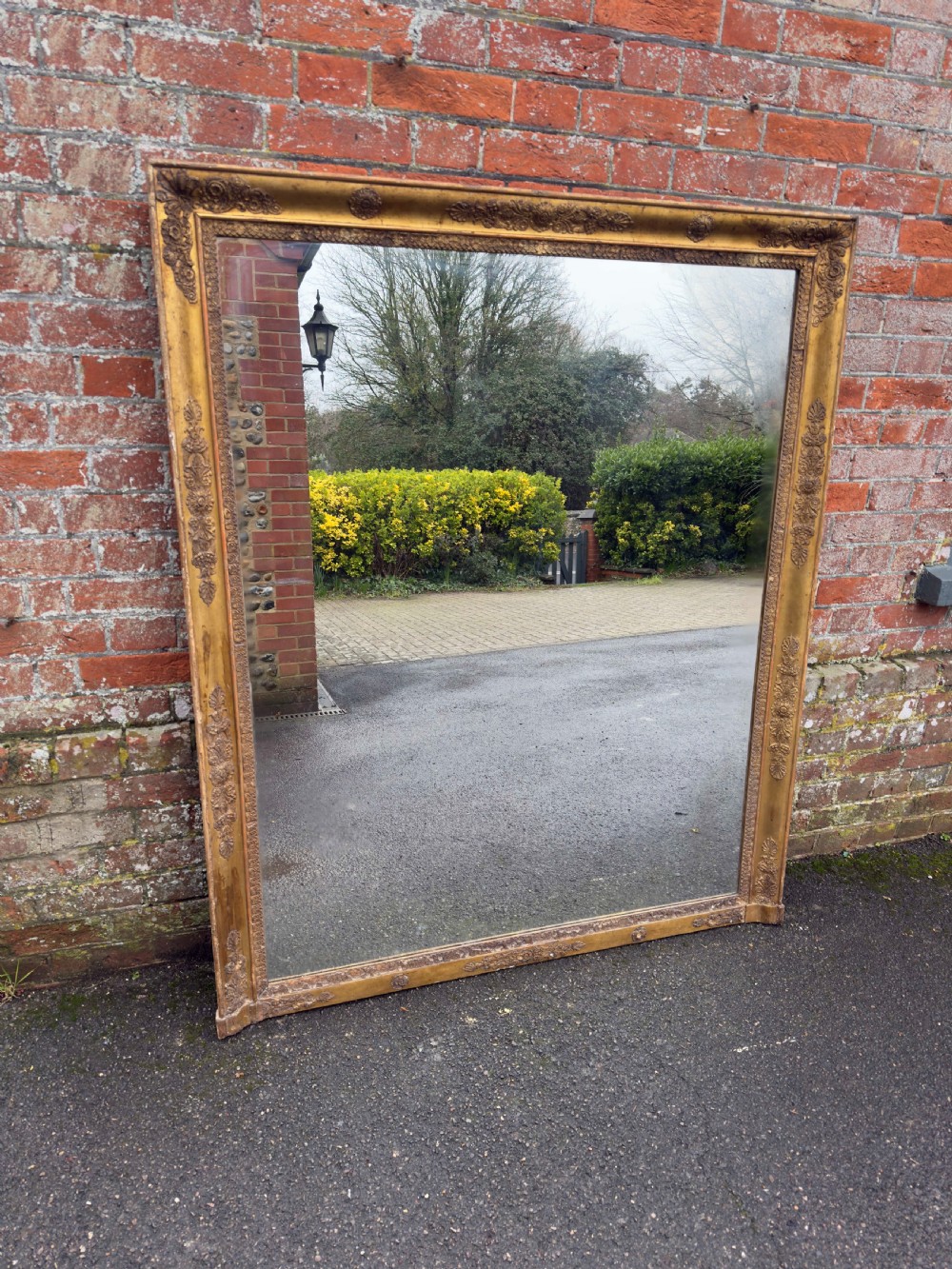 A large rectangular French 19th-century giltwood and gesso mirror featuring carved foliate mouldings and corner details.