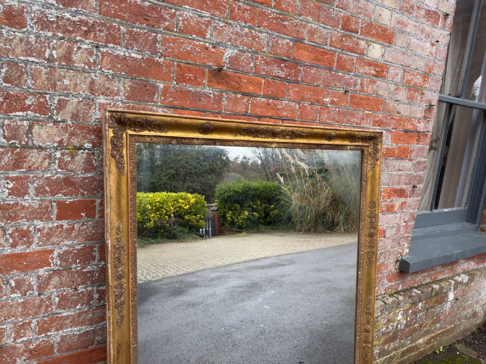 A large rectangular French 19th-century giltwood and gesso mirror featuring carved foliate mouldings and corner details. View V