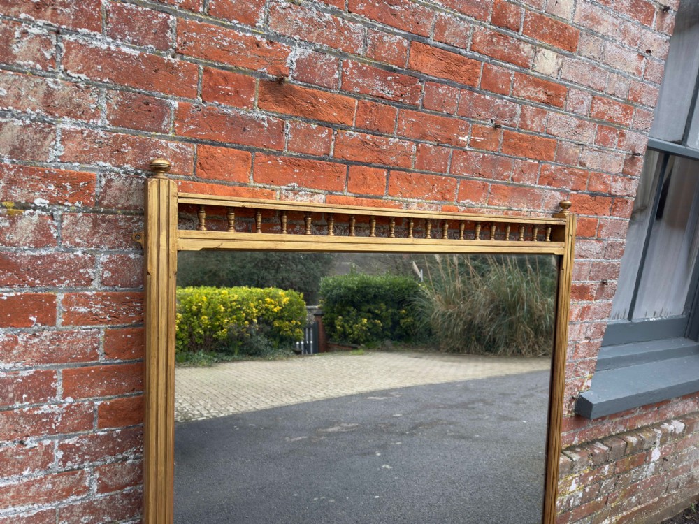 A large 19th-century rectangular gilt wood overmantel mirror featuring a upper spindle gallery and corner finials. View V