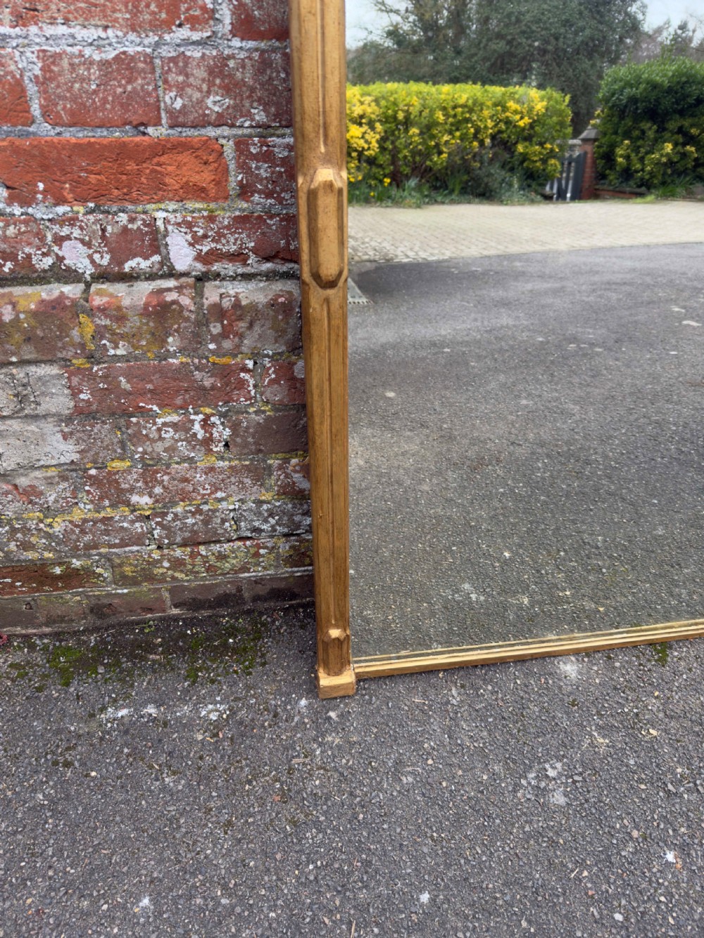 A large 19th-century rectangular giltwood overmantel mirror featuring a carved pediment with spindle detailing and foliate corner ornamentation. View IV