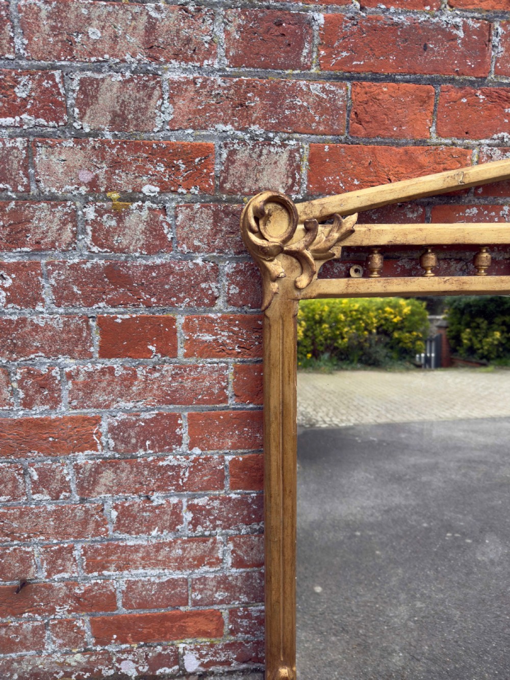 A large 19th-century rectangular giltwood overmantel mirror featuring a carved pediment with spindle detailing and foliate corner ornamentation. View VI