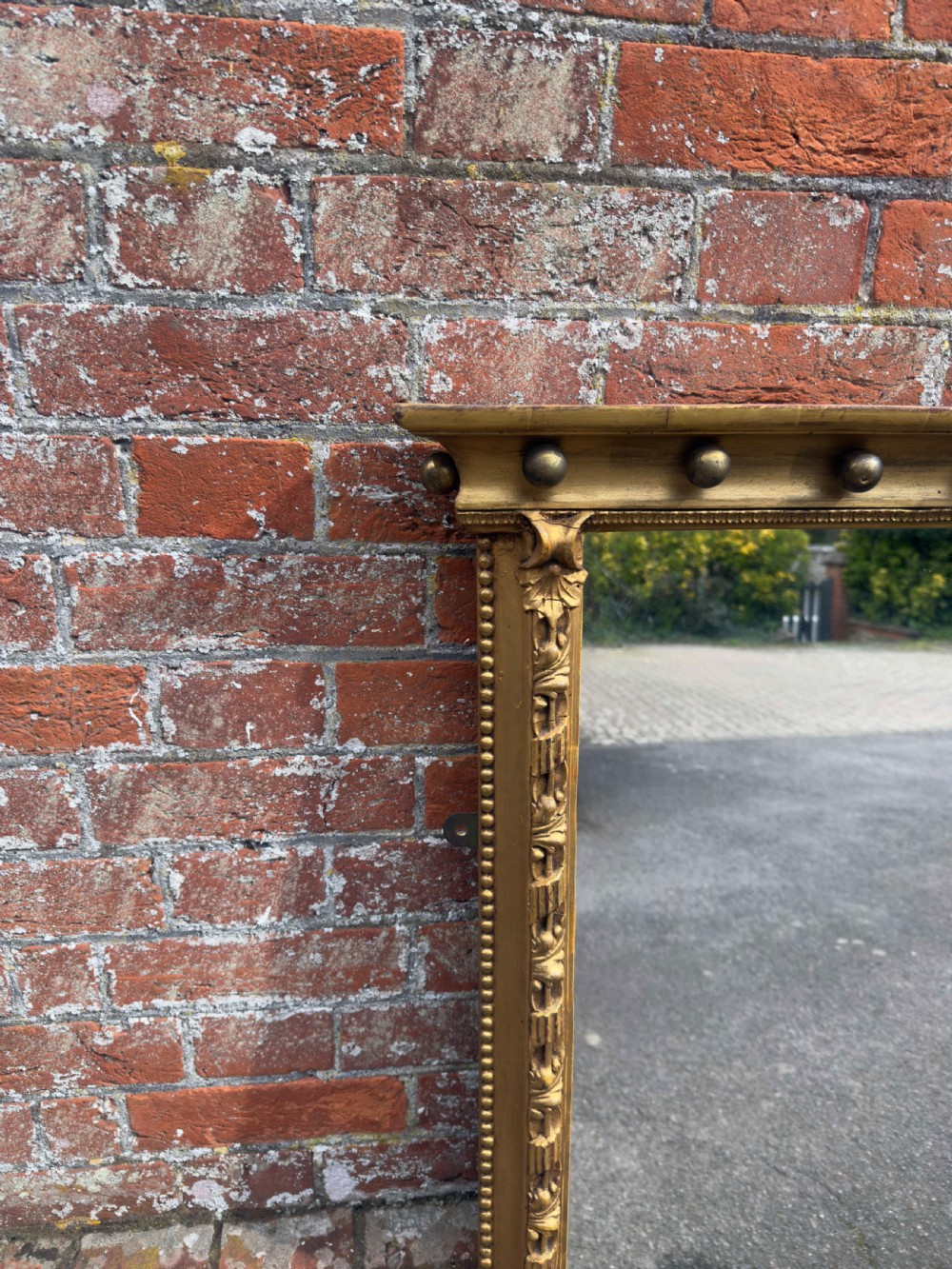 A large 19th-century rectangular giltwood and gesso overmantel mirror featuring a row of decorative spherules beneath the upper cornice and scrolled side feet. View II