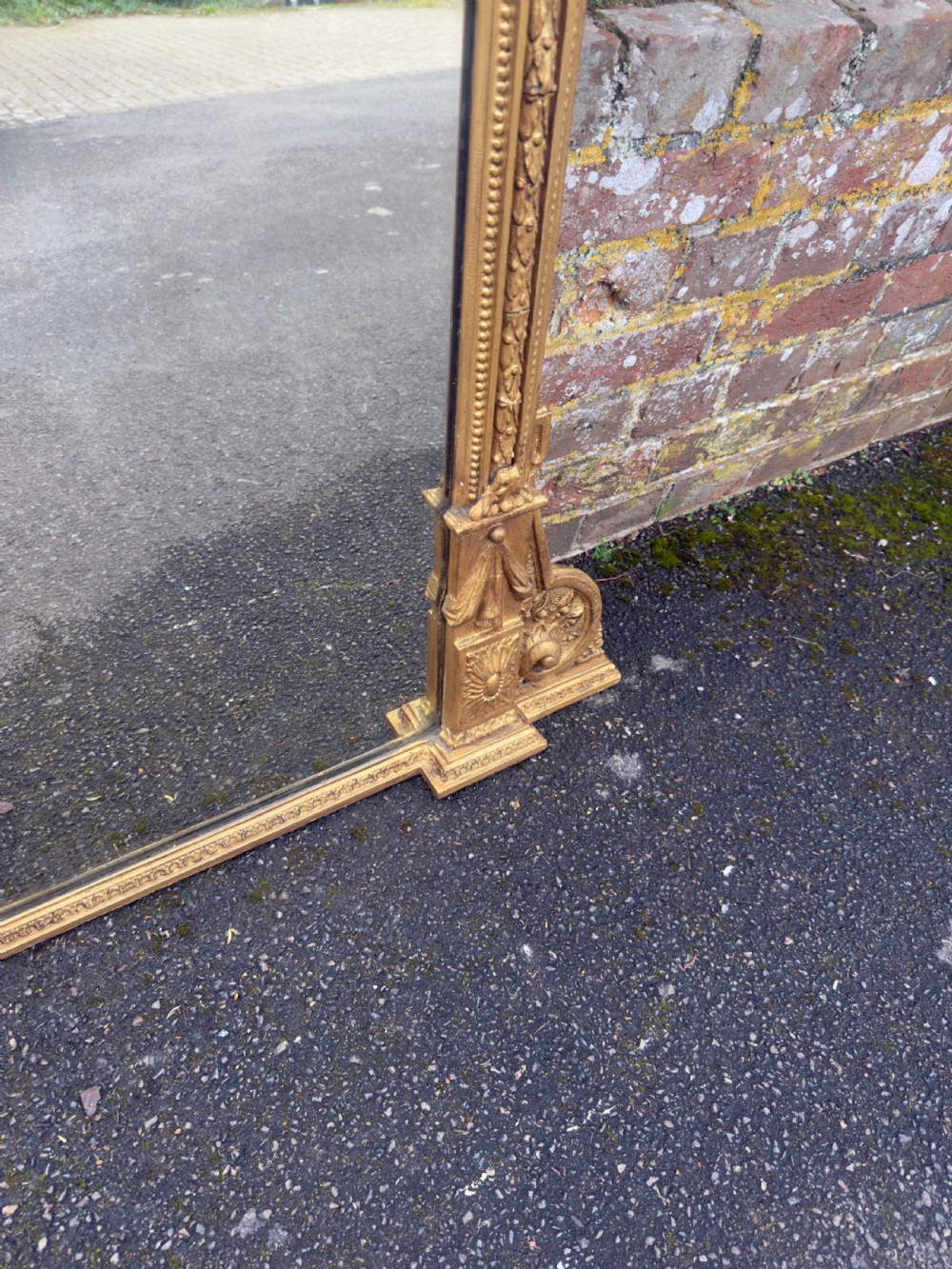 A nineteenth-century giltwood overmantel mirror with detailed gesso moulding, corner spandrels, and a central carved floral cresting. View VII
