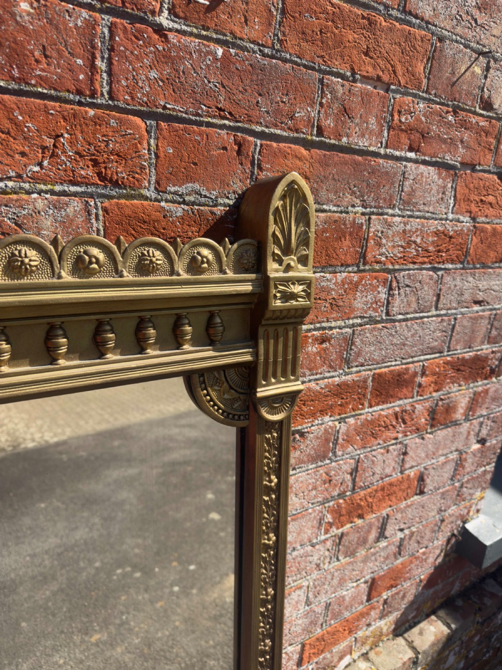 A large 19th-century rectangular giltwood overmantel mirror featuring a carved pediment with a lion mask crest and fluted side pilasters. View II