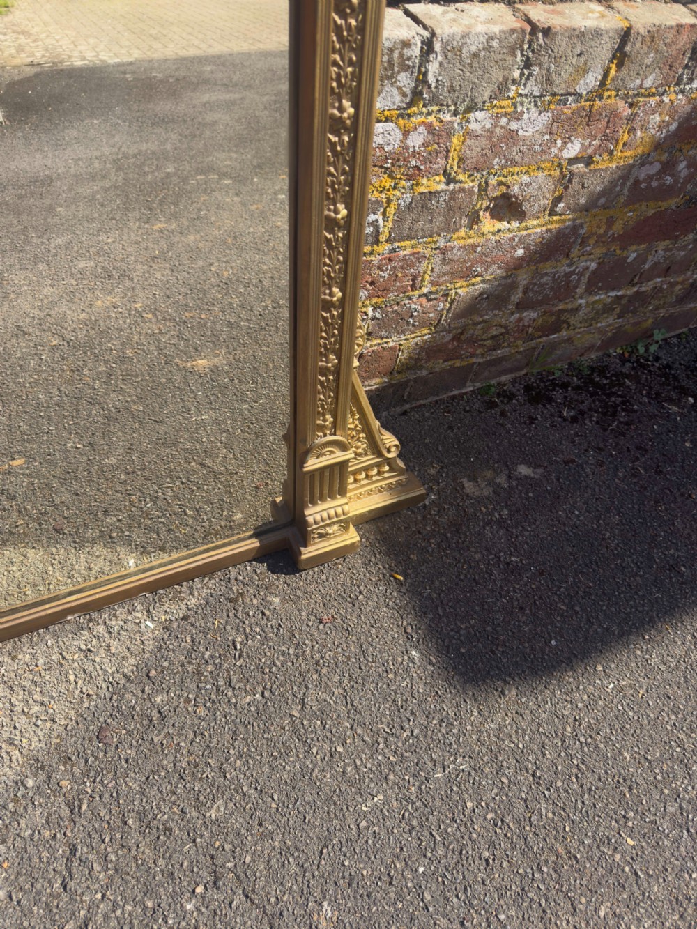 A large 19th-century rectangular giltwood overmantel mirror featuring a carved pediment with a lion mask crest and fluted side pilasters. View V