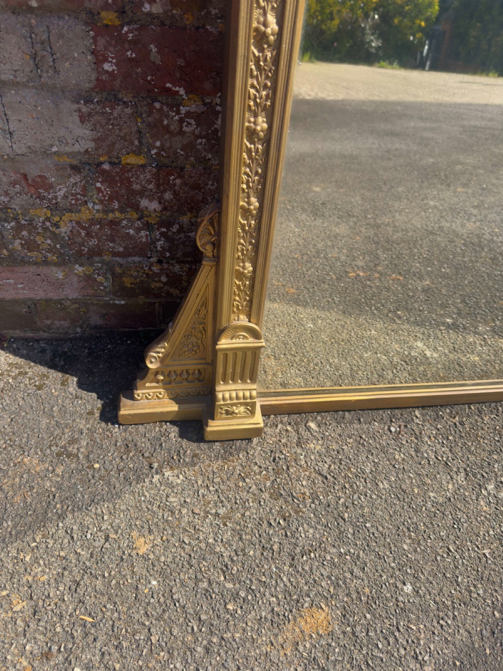 A large 19th-century rectangular giltwood overmantel mirror featuring a carved pediment with a lion mask crest and fluted side pilasters. View VII