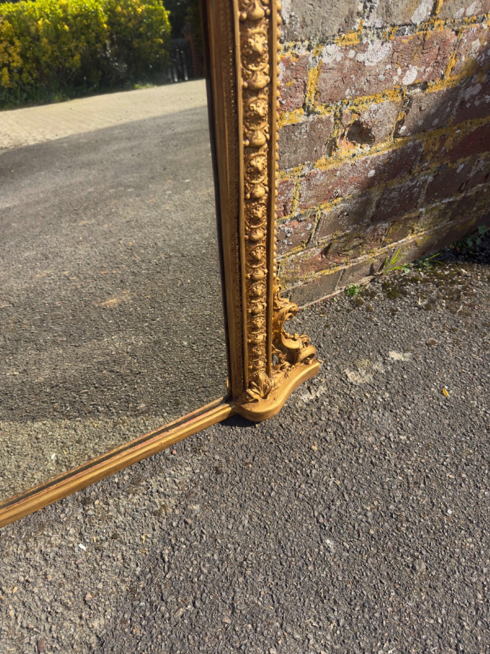 A 19th-century Victorian arched overmantel mirror featuring a gilded wood and gesso frame with carved bead detailing and ornate side flourishes. View III