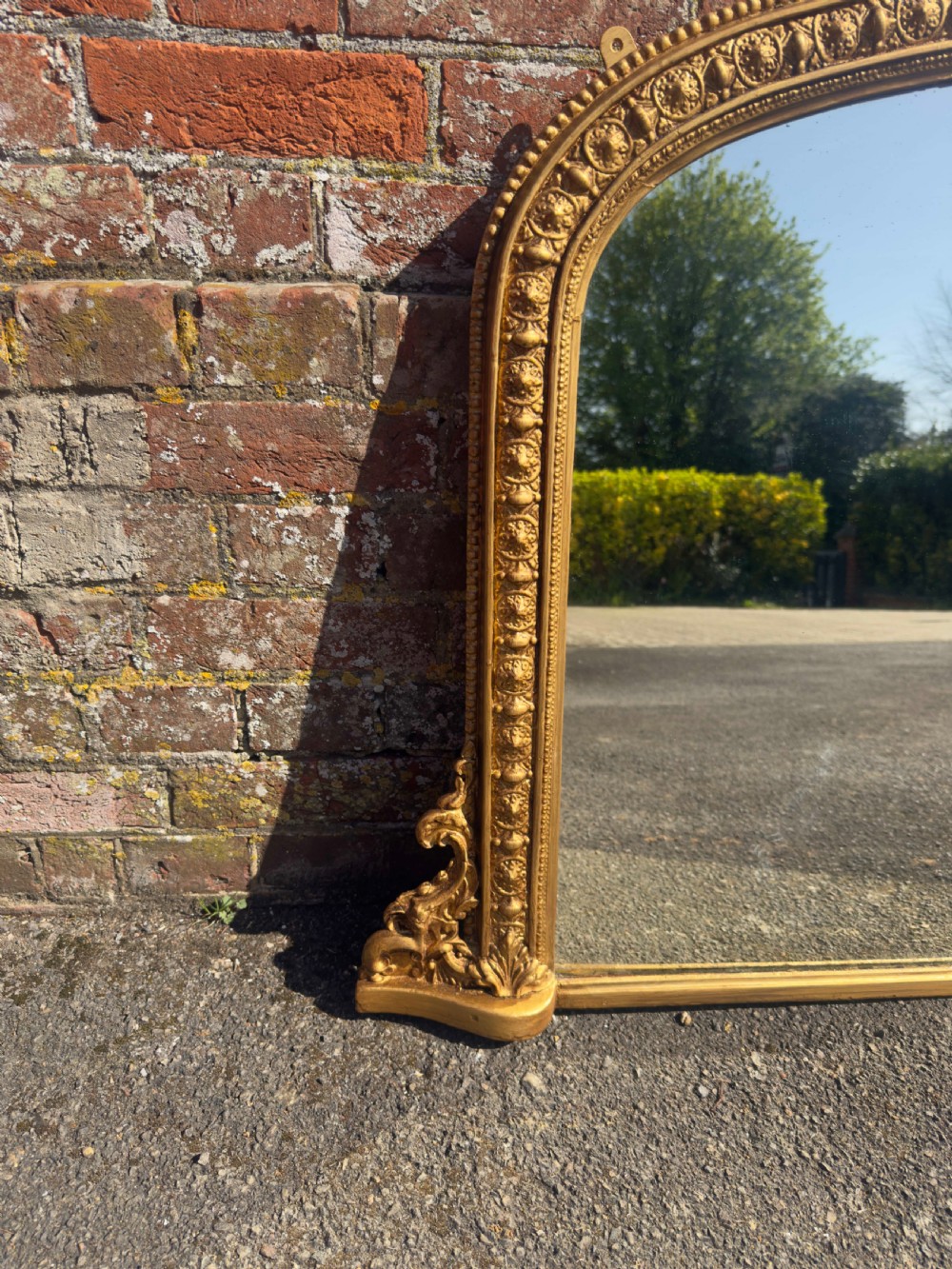 A 19th-century Victorian arched overmantel mirror featuring a gilded wood and gesso frame with carved bead detailing and ornate side flourishes. View V