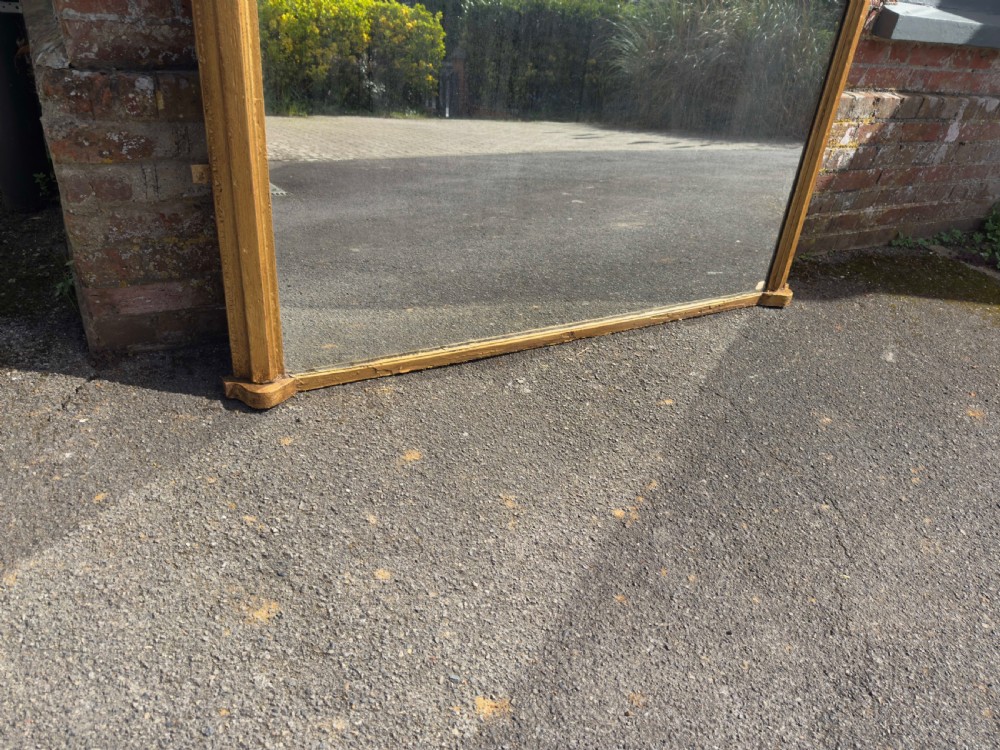 A large 19th-century arched overmantel mirror featuring a gilded wood and gesso frame with rounded top corners and subtle moulding details. View V