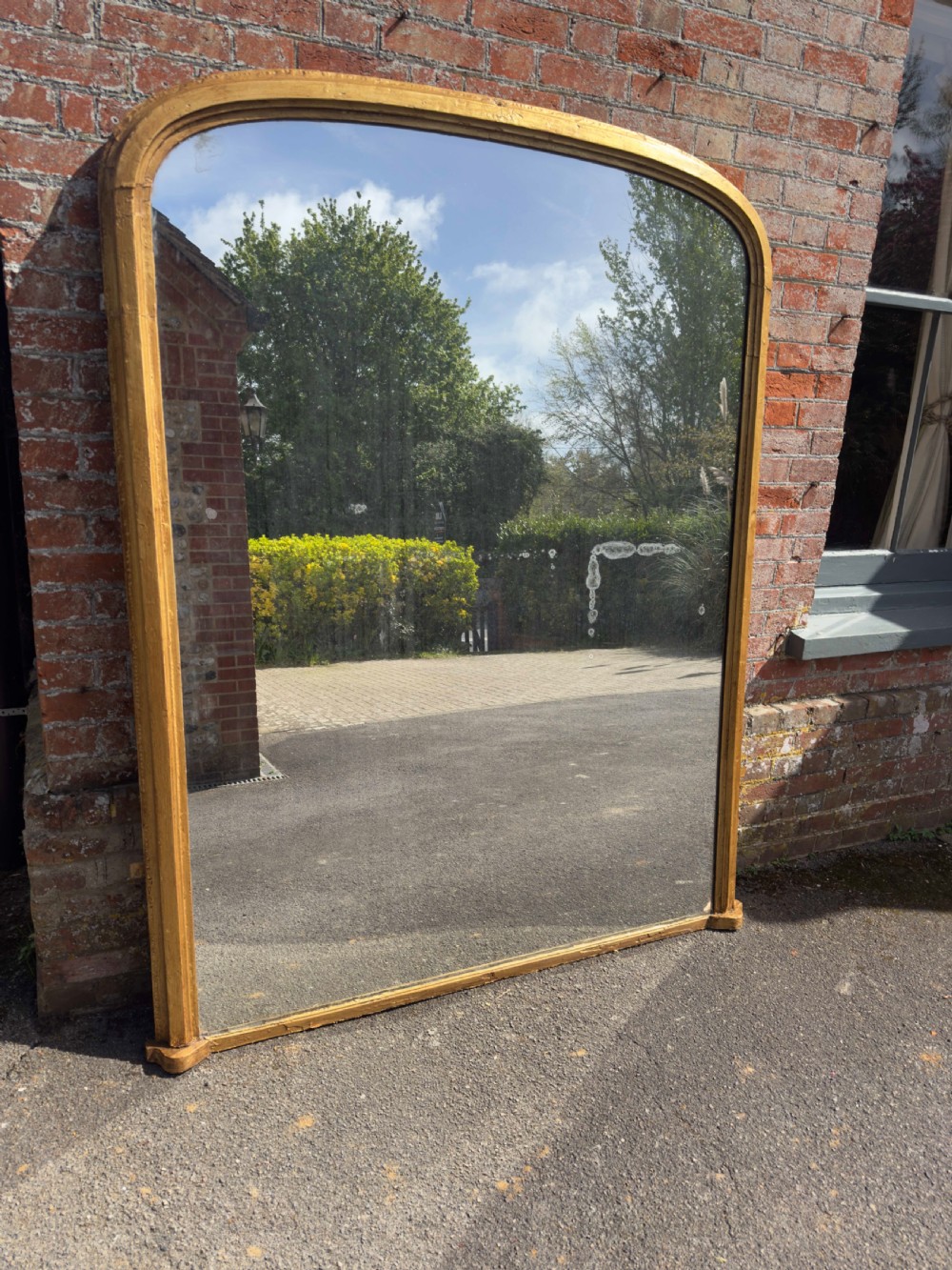 A large 19th-century arched overmantel mirror featuring a gilded wood and gesso frame with rounded top corners and subtle moulding details. View VI