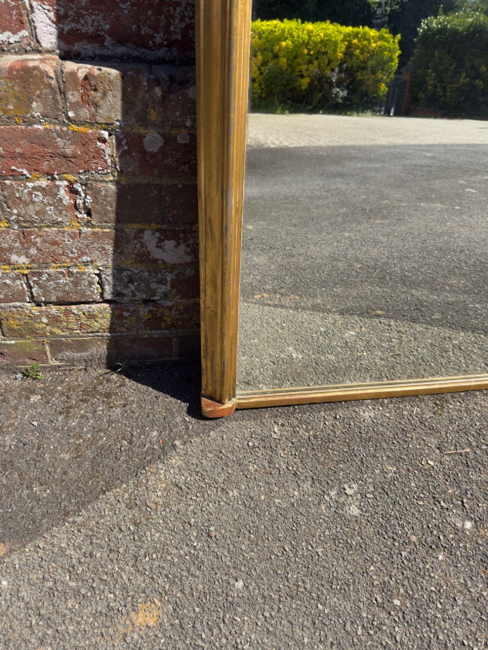 A large nineteenth-century English overmantel mirror featuring a gilded wood and gesso frame with an arched top and moulded edges. View IV