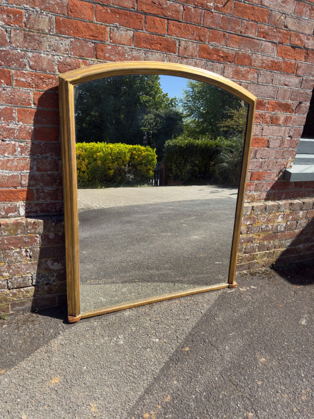 A large nineteenth-century English overmantel mirror featuring a gilded wood and gesso frame with an arched top and moulded edges. View VII