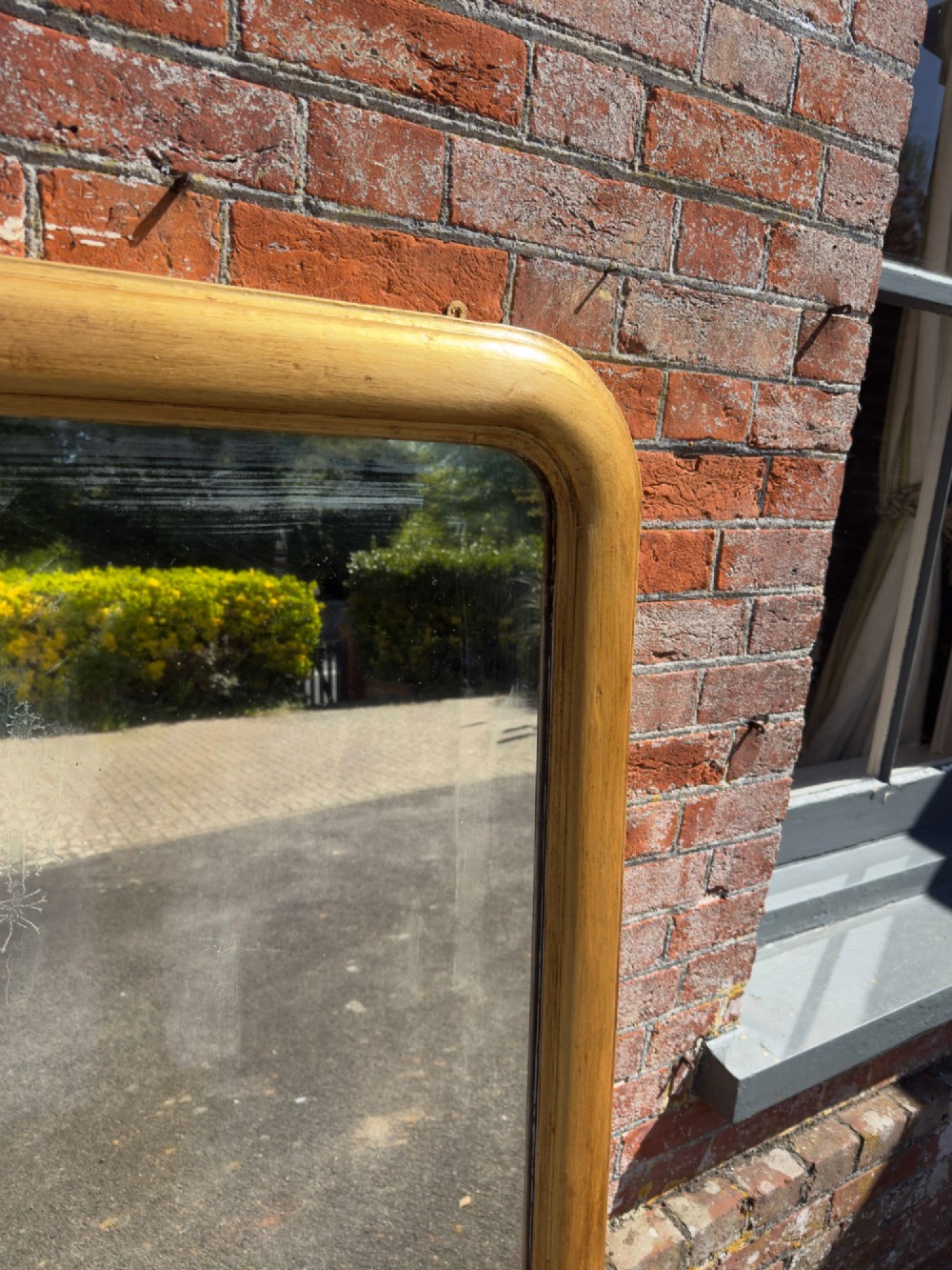 A large nineteenth-century English giltwood overmantel mirror featuring an arched top and rounded upper shoulders. View II