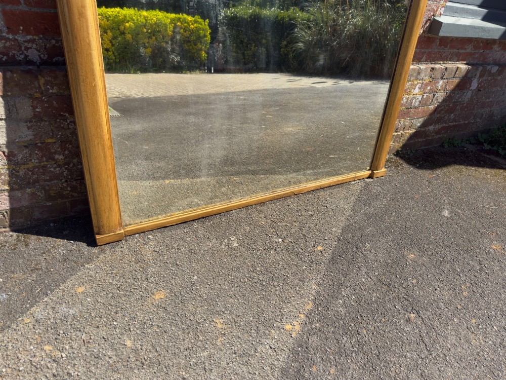A large nineteenth-century English giltwood overmantel mirror featuring an arched top and rounded upper shoulders. View IV