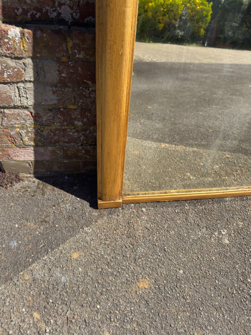 A large nineteenth-century English giltwood overmantel mirror featuring an arched top and rounded upper shoulders. View V