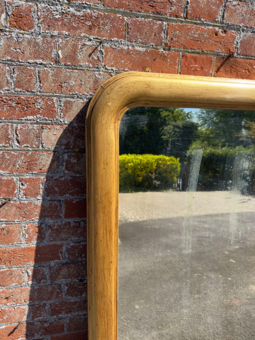 A large nineteenth-century English giltwood overmantel mirror featuring an arched top and rounded upper shoulders. View VI