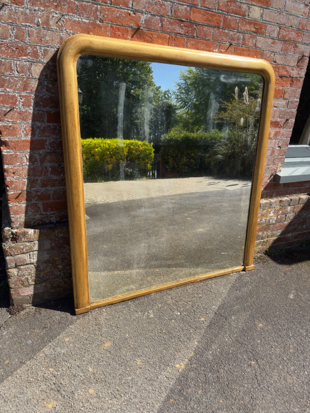A large nineteenth-century English giltwood overmantel mirror featuring an arched top and rounded upper shoulders. View VII