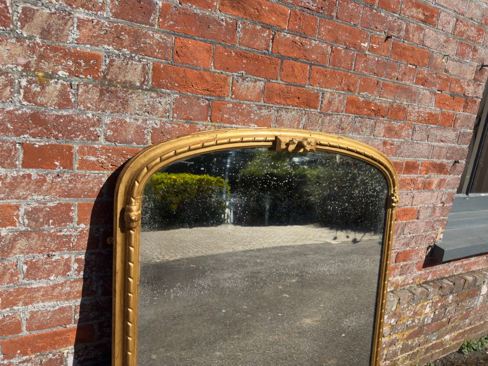 A 19th-century arched overmantel mirror featuring a gold giltwood rope-twist frame and original foxed glass. View II