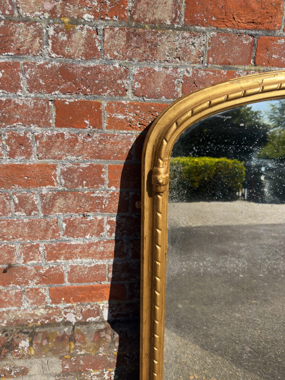 A 19th-century arched overmantel mirror featuring a gold giltwood rope-twist frame and original foxed glass. View V