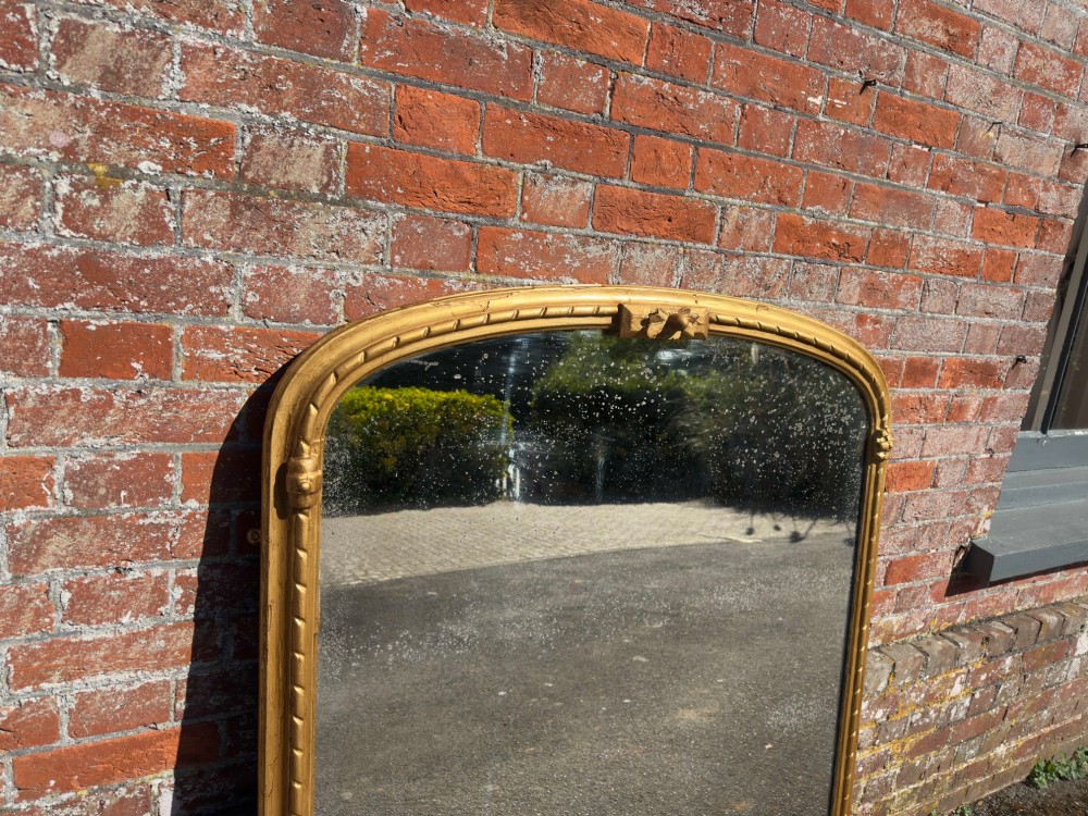 A 19th-century arched overmantel mirror featuring a gold giltwood rope-twist frame and original foxed glass. View VI