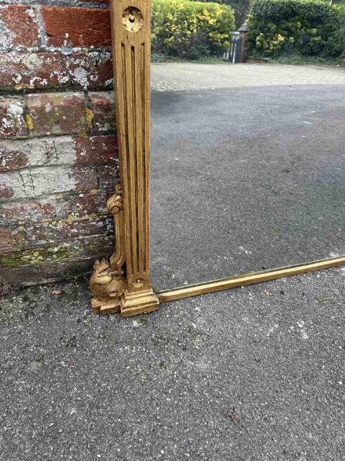 A large 19th-century English giltwood overmantel mirror featuring ribbed pilasters and rosette carvings around a rectangular mirror glass plate. View III