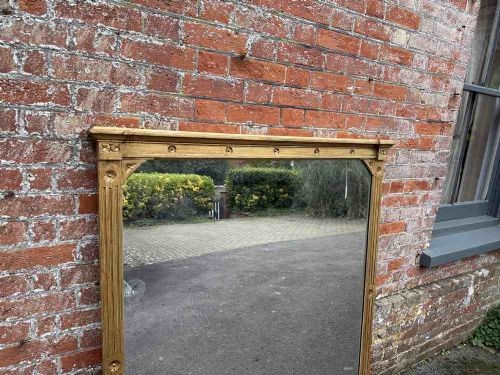 A large 19th-century English giltwood overmantel mirror featuring ribbed pilasters and rosette carvings around a rectangular mirror glass plate. View IV
