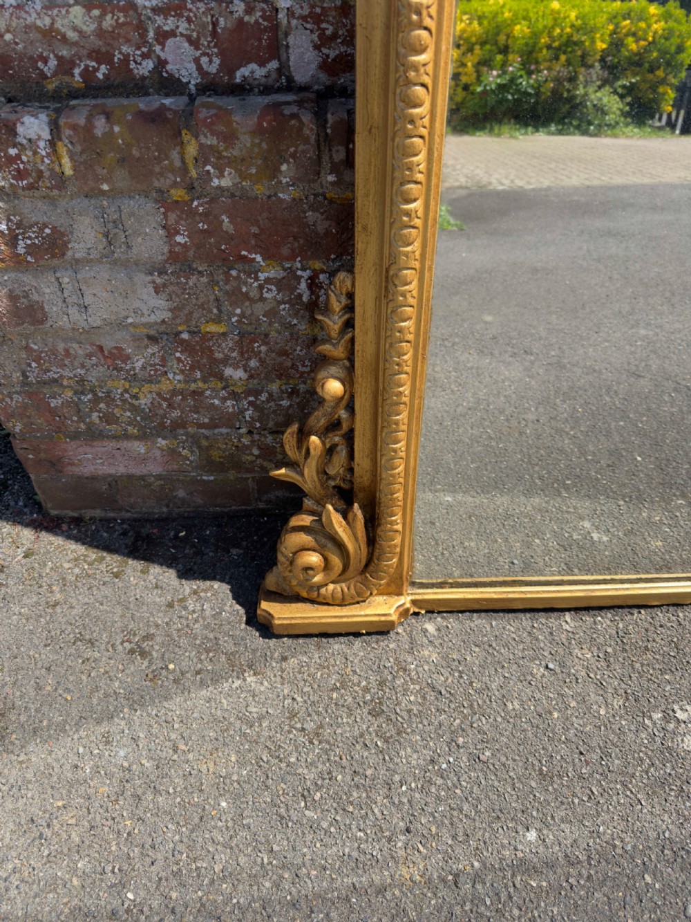 A 19th-century English giltwood overmantel mirror featuring an arched top frame and carved acanthus leaf details at the base. View II