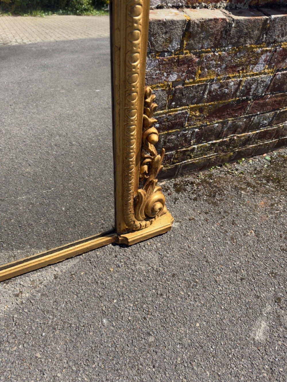 A 19th-century English giltwood overmantel mirror featuring an arched top frame and carved acanthus leaf details at the base. View III