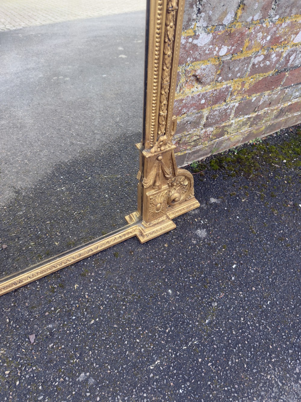 A 19th-century English giltwood overmantel mirror featuring an arched top frame and carved acanthus leaf details at the base. View VI