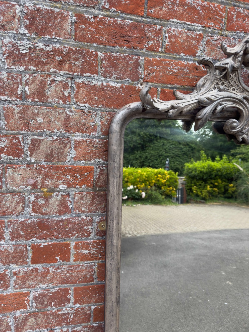 A tall 19th-century French arched mirror with a carved foliate gesso crest and aged silver leaf finish. View VI