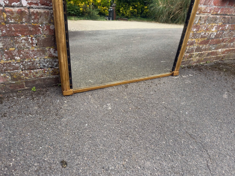 A large Victorian arched overmantel mirror featuring a gilded wood frame with a dark inner border detailing. View III