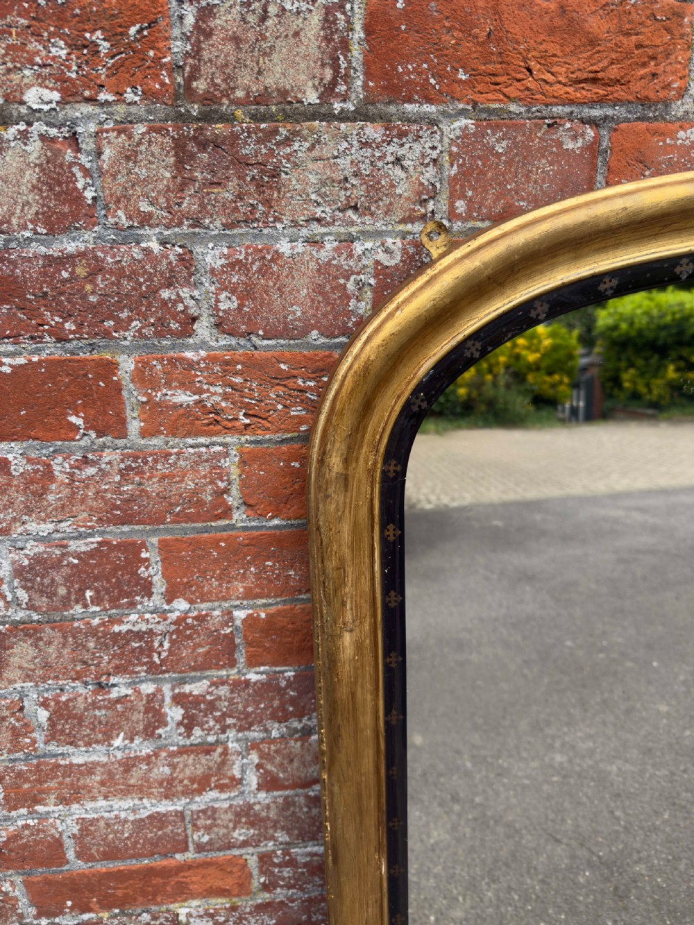 A large Victorian arched overmantel mirror featuring a gilded wood frame with a dark inner border detailing. View VI