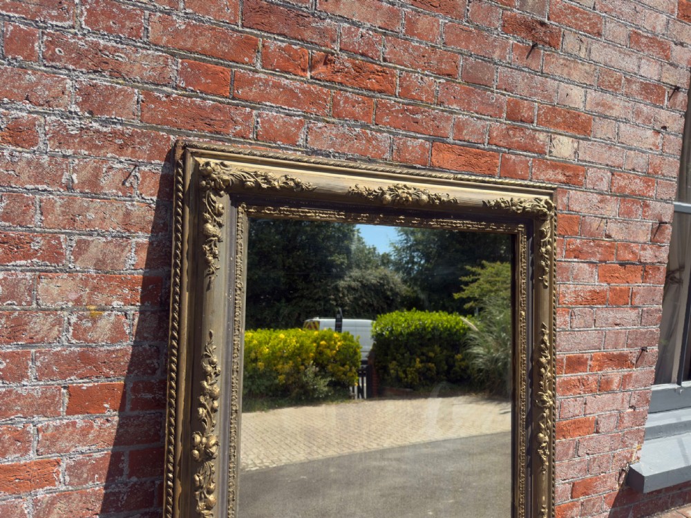 A large 19th-century rectangular French mirror featuring an ornate gilded gesso frame with detailed floral and leaf mouldings. View III