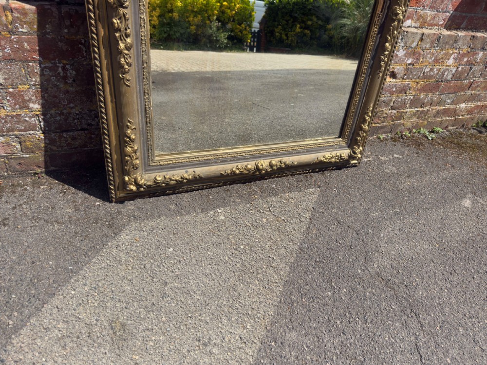 A large 19th-century rectangular French mirror featuring an ornate gilded gesso frame with detailed floral and leaf mouldings. View VI