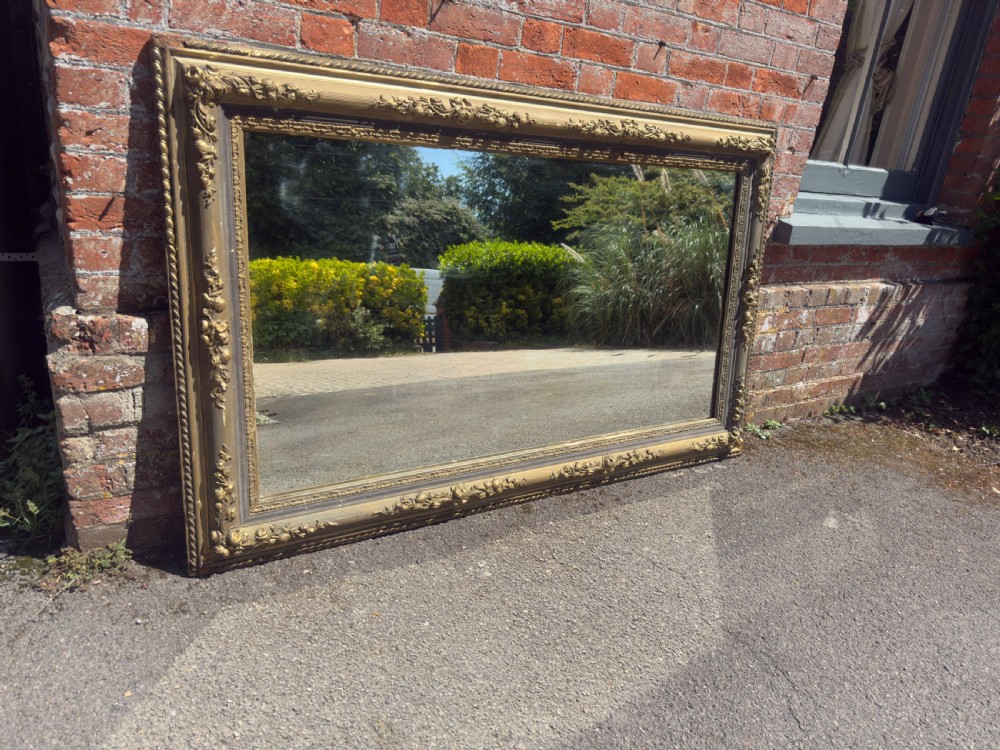 A large 19th-century rectangular French mirror featuring an ornate gilded gesso frame with detailed floral and leaf mouldings. View VII