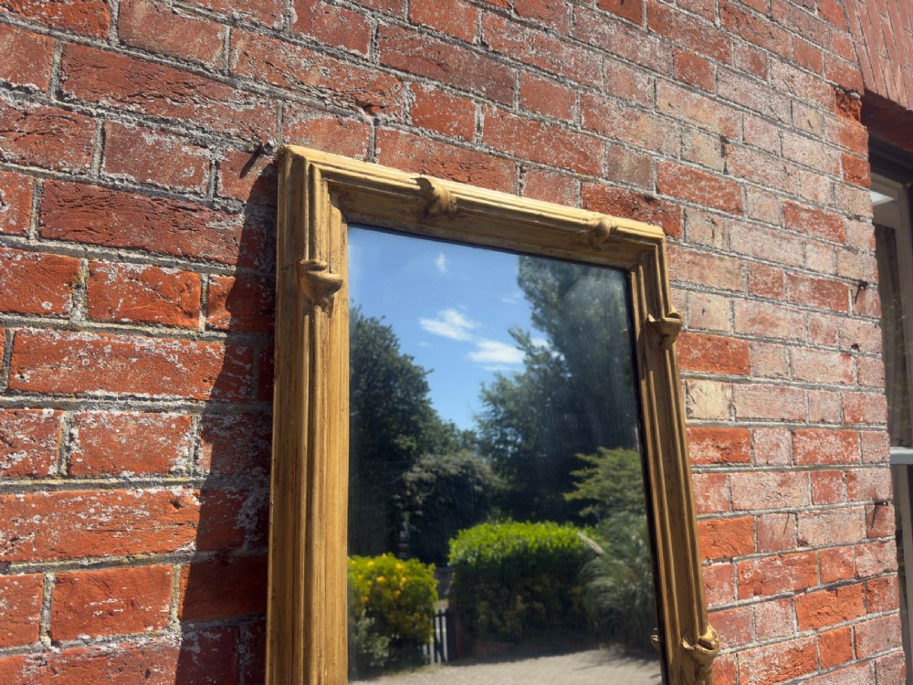 A large rectangular antique English pier mirror featuring a reeded giltwood frame embellished with carved leaf clasp accents. View II