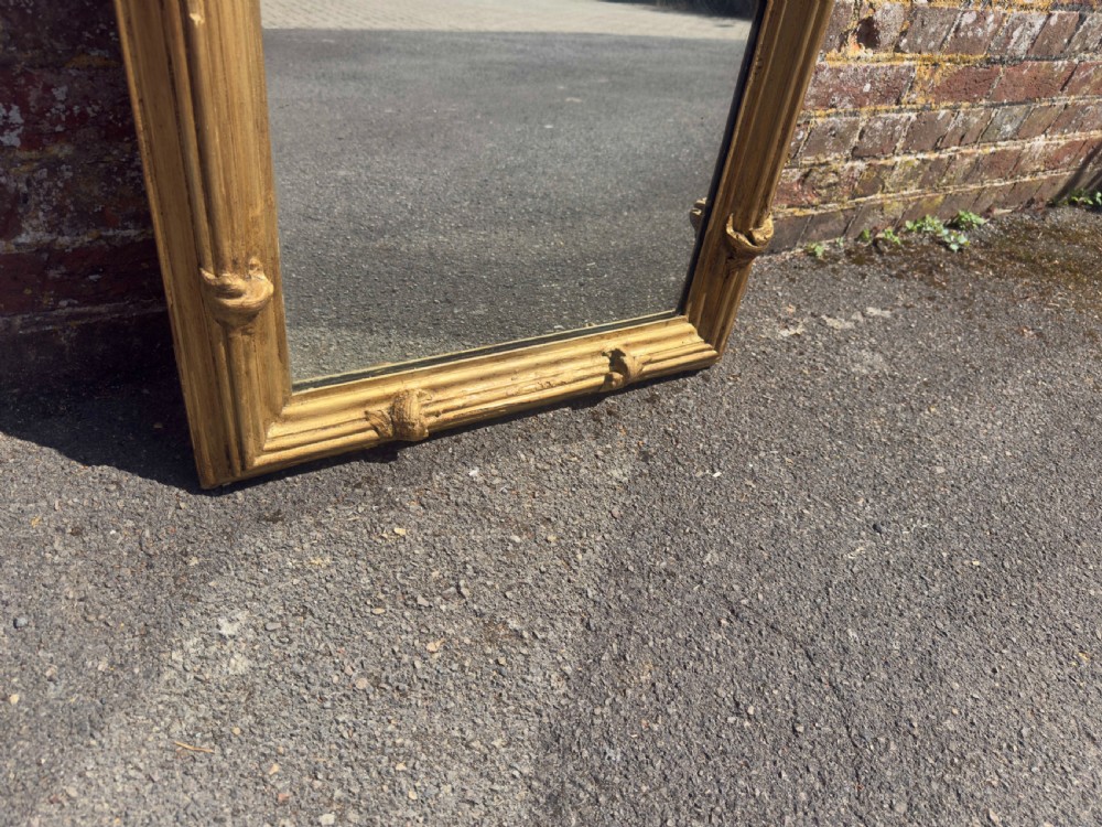 A large rectangular antique English pier mirror featuring a reeded giltwood frame embellished with carved leaf clasp accents. View III