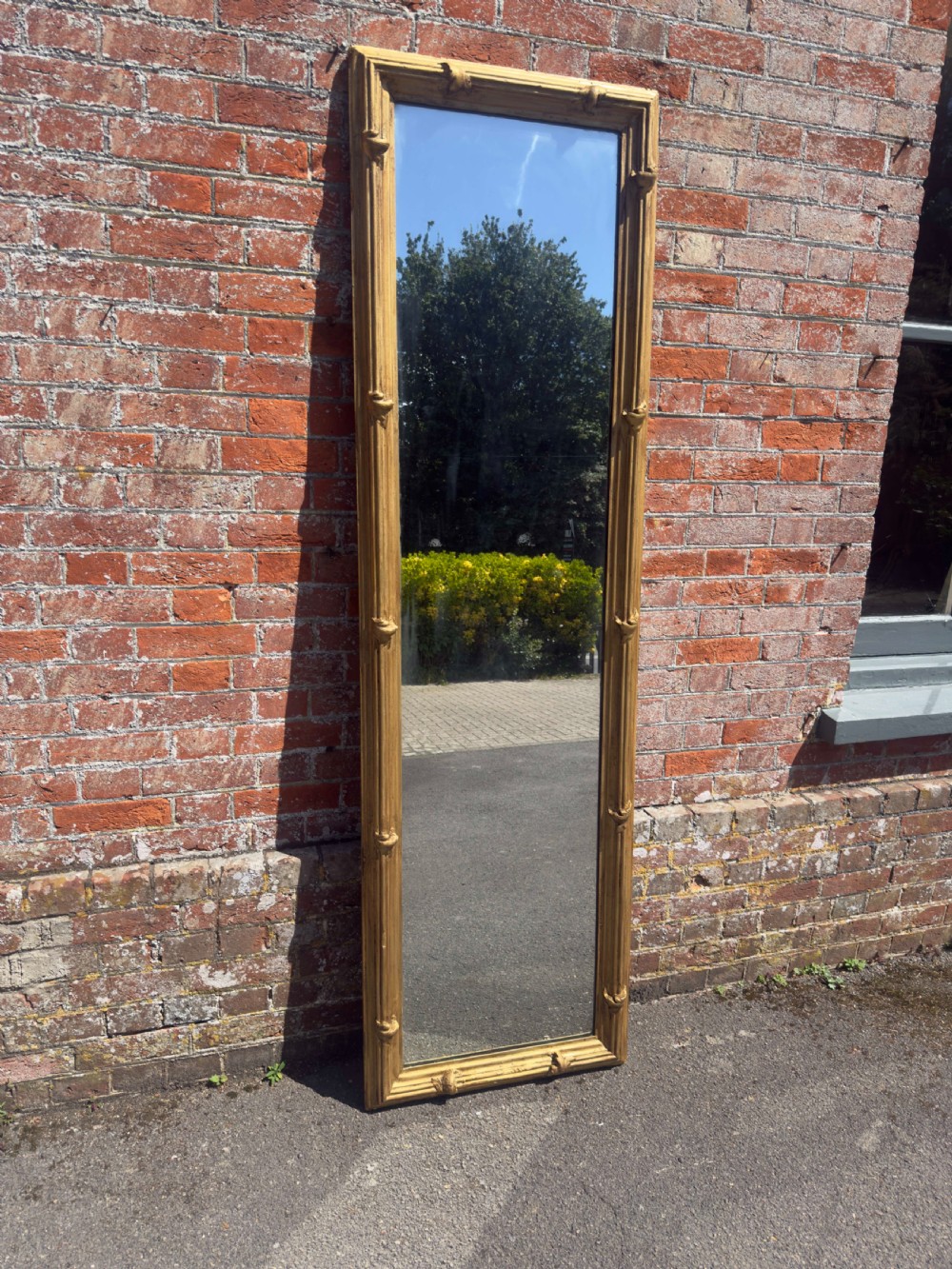 A large rectangular antique English pier mirror featuring a reeded giltwood frame embellished with carved leaf clasp accents. View V